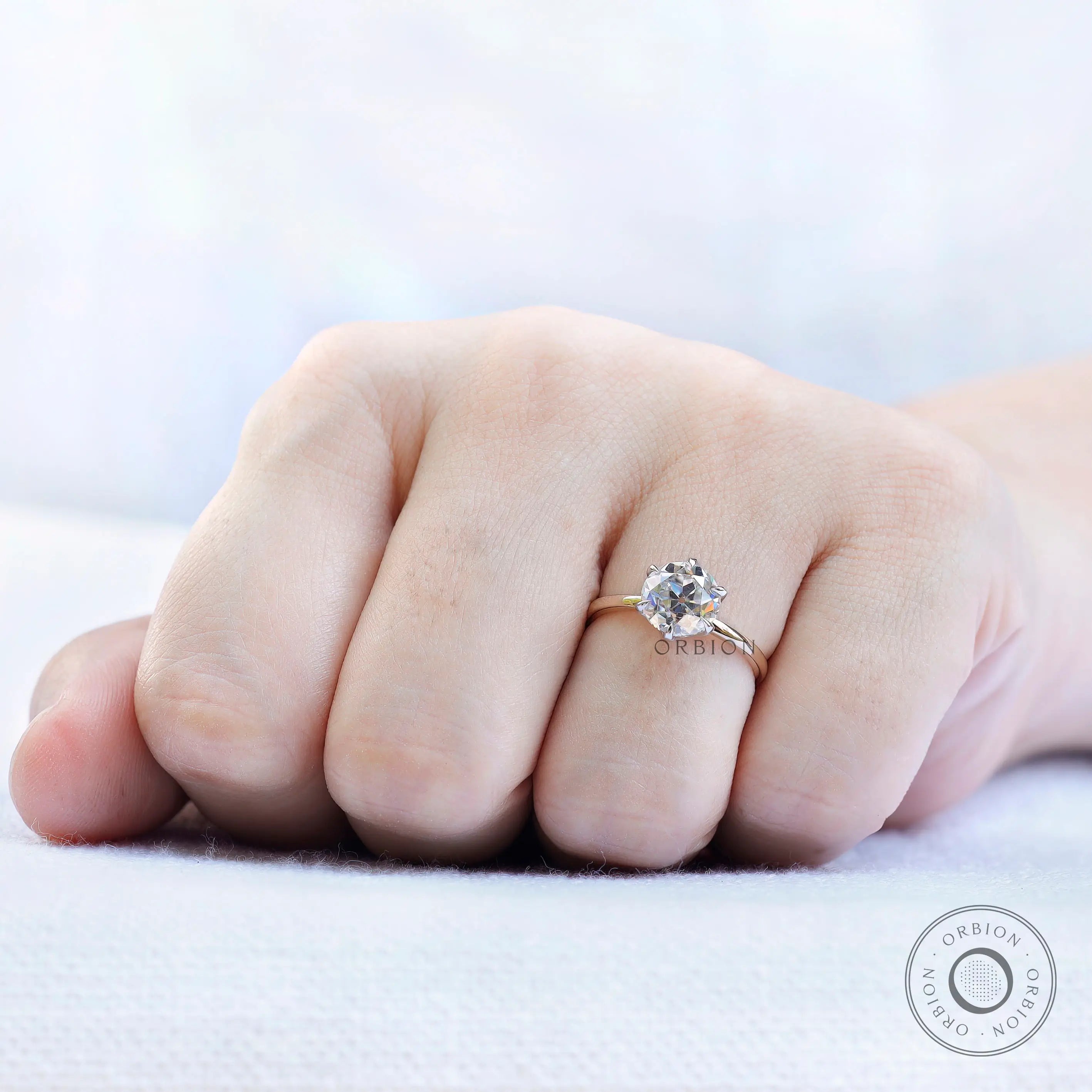 Rare profile view  of the OEC Moissanite engagement ring in dual-tone gold.