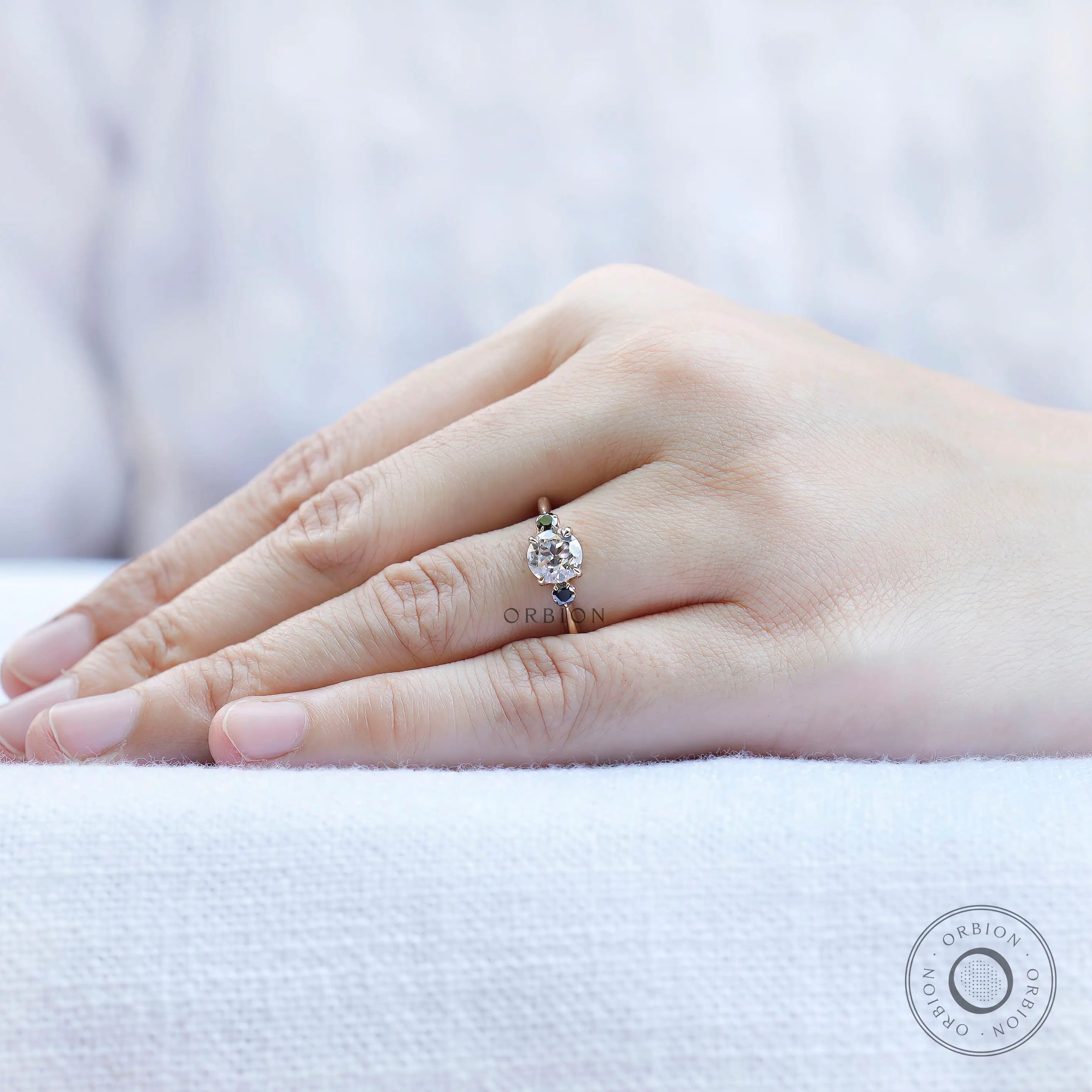 Minimal three stone moissanite ring on hand