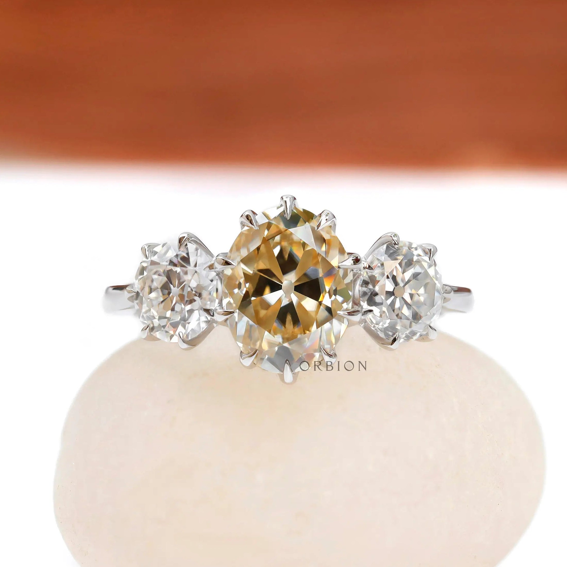 Champagne oval moissanite three stone engagement ring in 18k white gold