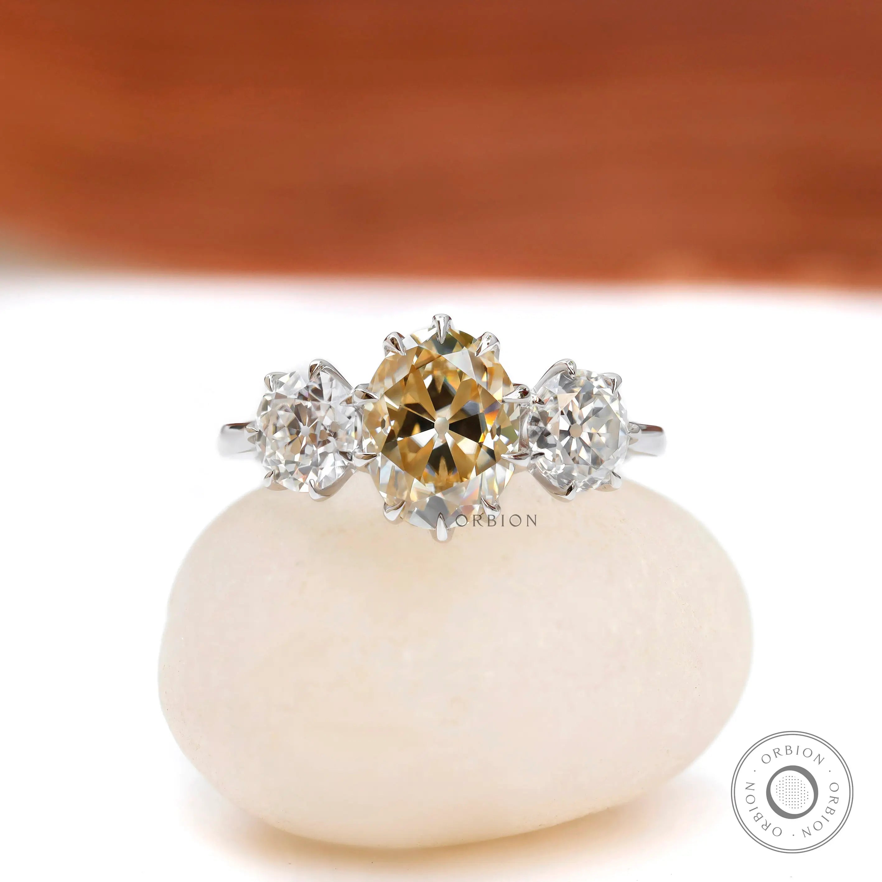Champagne oval moissanite three stone engagement ring in 18k white gold