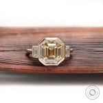 Emerald step cut light champagne moissanite bezel set engagement ring in yellow gold