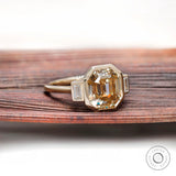 Bezel set emerald cut moissanite three stone ring with baguette sides