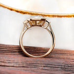 Yellow gold bezel set three stone moissanite ring close up