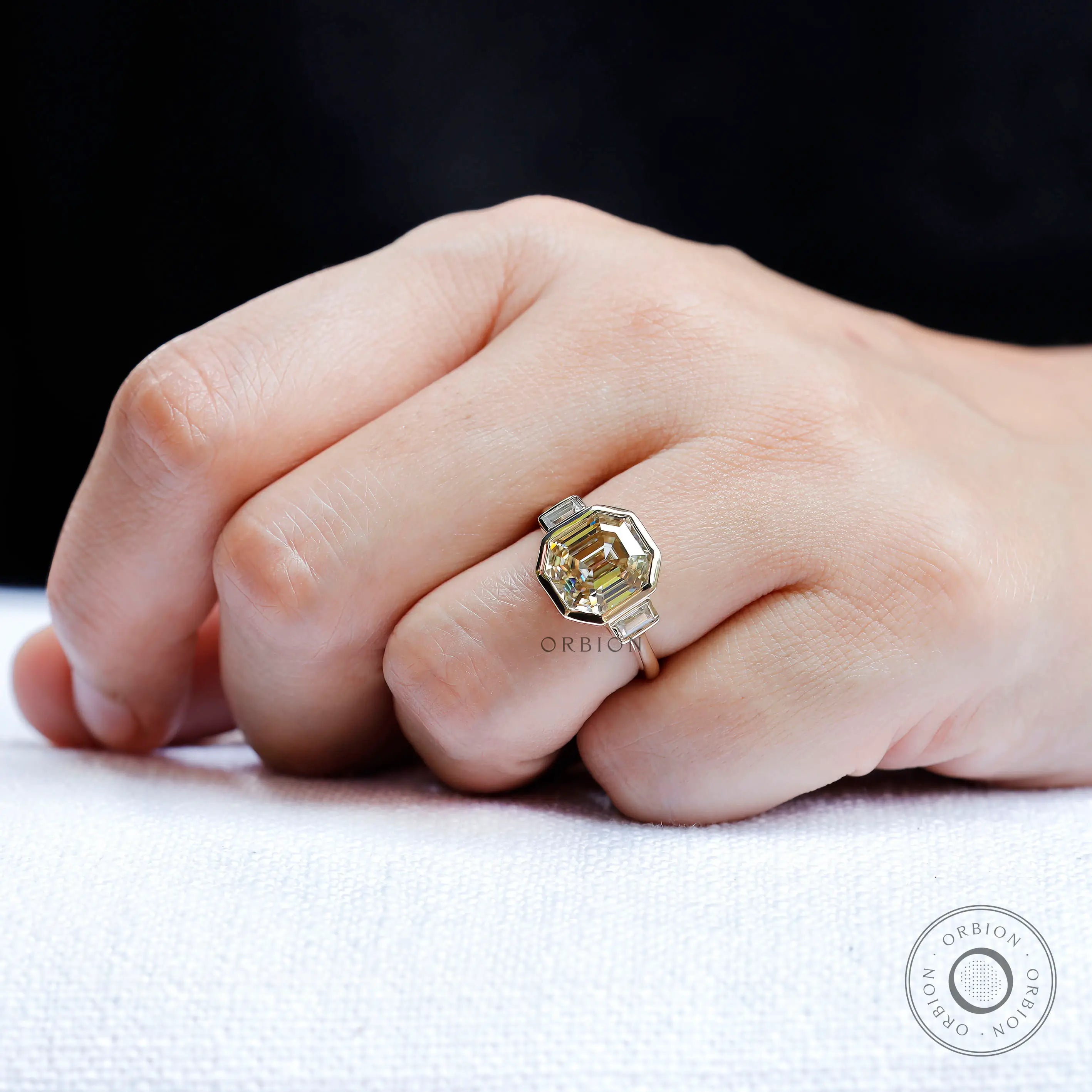 Light champagne emerald moissanite ring worn on hand