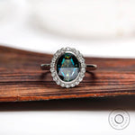 Oval bluish green rose cut moissanite halo ring in 10K white gold front view