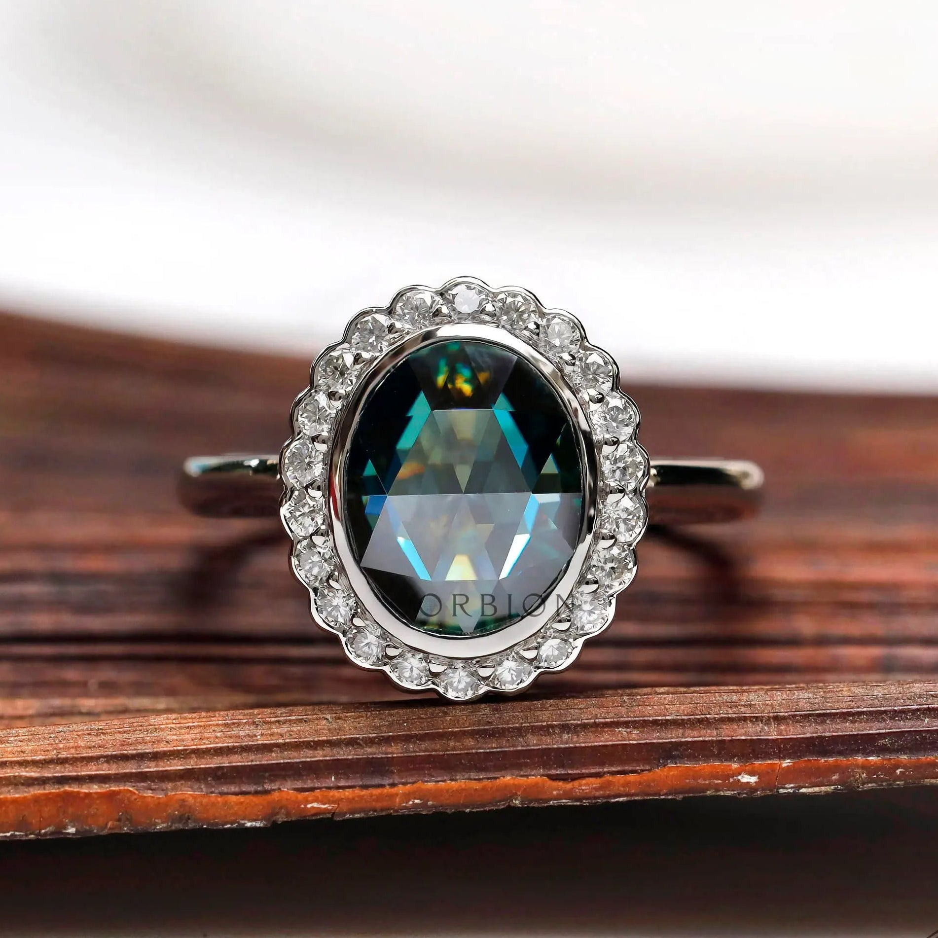 Oval bluish green rose cut moissanite halo ring in 10K white gold front view