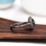 Side angle of oval rose cut bluish green moissanite halo engagement ring