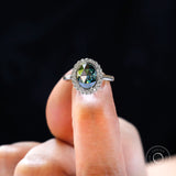 Top view of oval rose cut moissanite halo engagement ring on hand