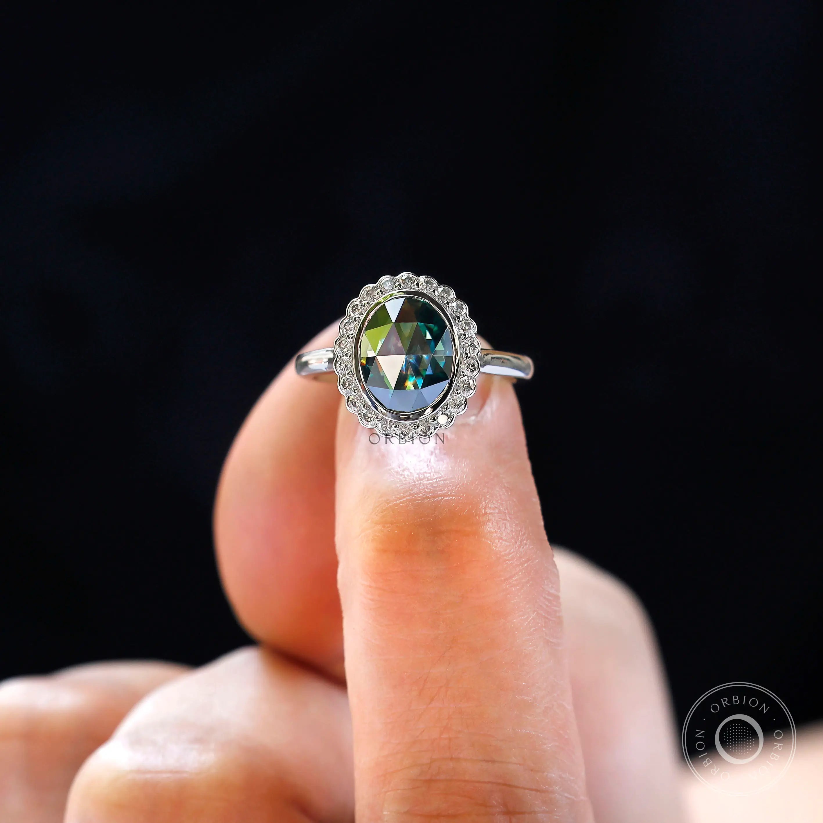 Top view of oval rose cut moissanite halo engagement ring on hand