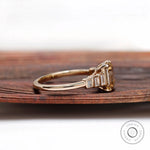 Side profile of emerald cut champagne moissanite ring with graduated baguette stones