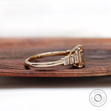 Side profile of emerald cut champagne moissanite ring with graduated baguette stones