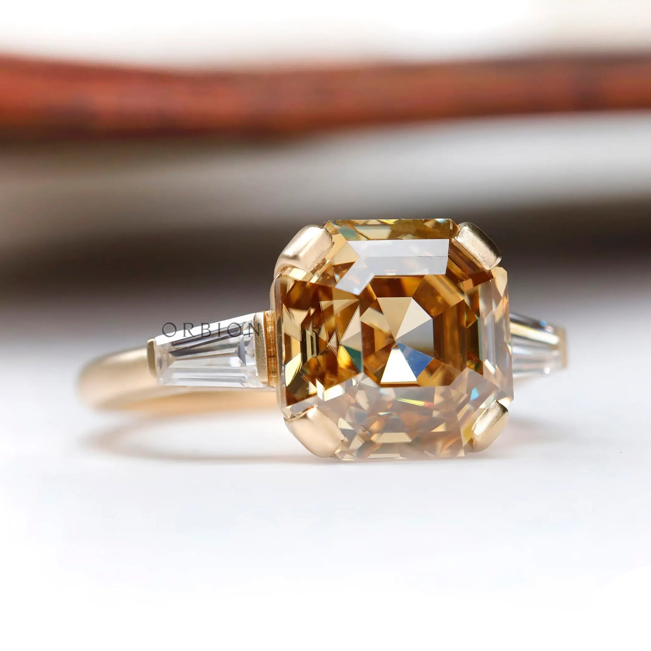 Three stone ring with octagon dark champagne moissanite in yellow gold