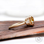 Side view of three stone moissanite ring with baguette accents
