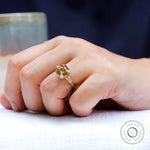 Three stone yellow gold moissanite ring worn on hand