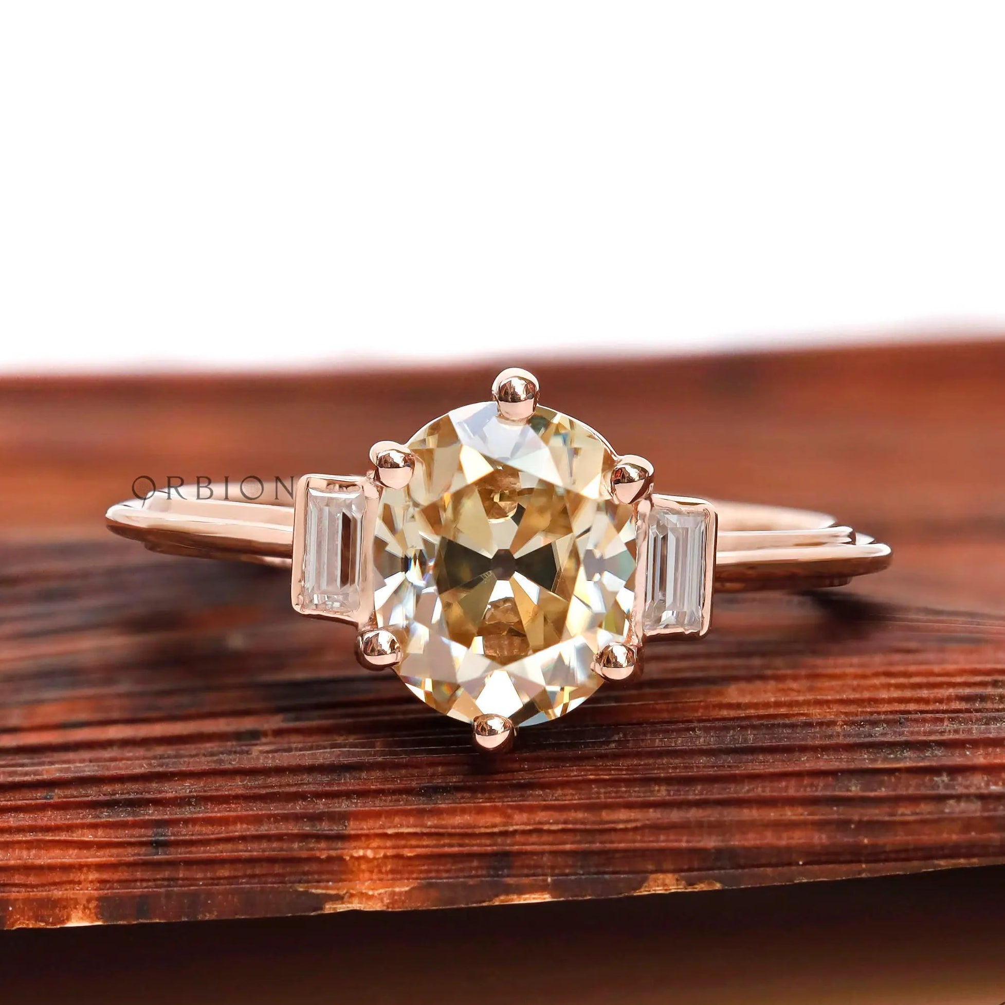 Front view of Champagne OEC Moissanite ring with baguette accents in rose gold.