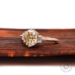 Angled view of champagne OEC Moissanite three-stone ring.