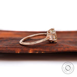 Side view of Champagne OEC Moissanite ring with baguette accents in rose gold.