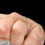 Close-up of hand with Champagne OEC Moissanite ring with baguette accents in rose gold