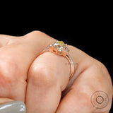 Close-up of hand with Champagne OEC Moissanite ring with baguette accents in rose gold