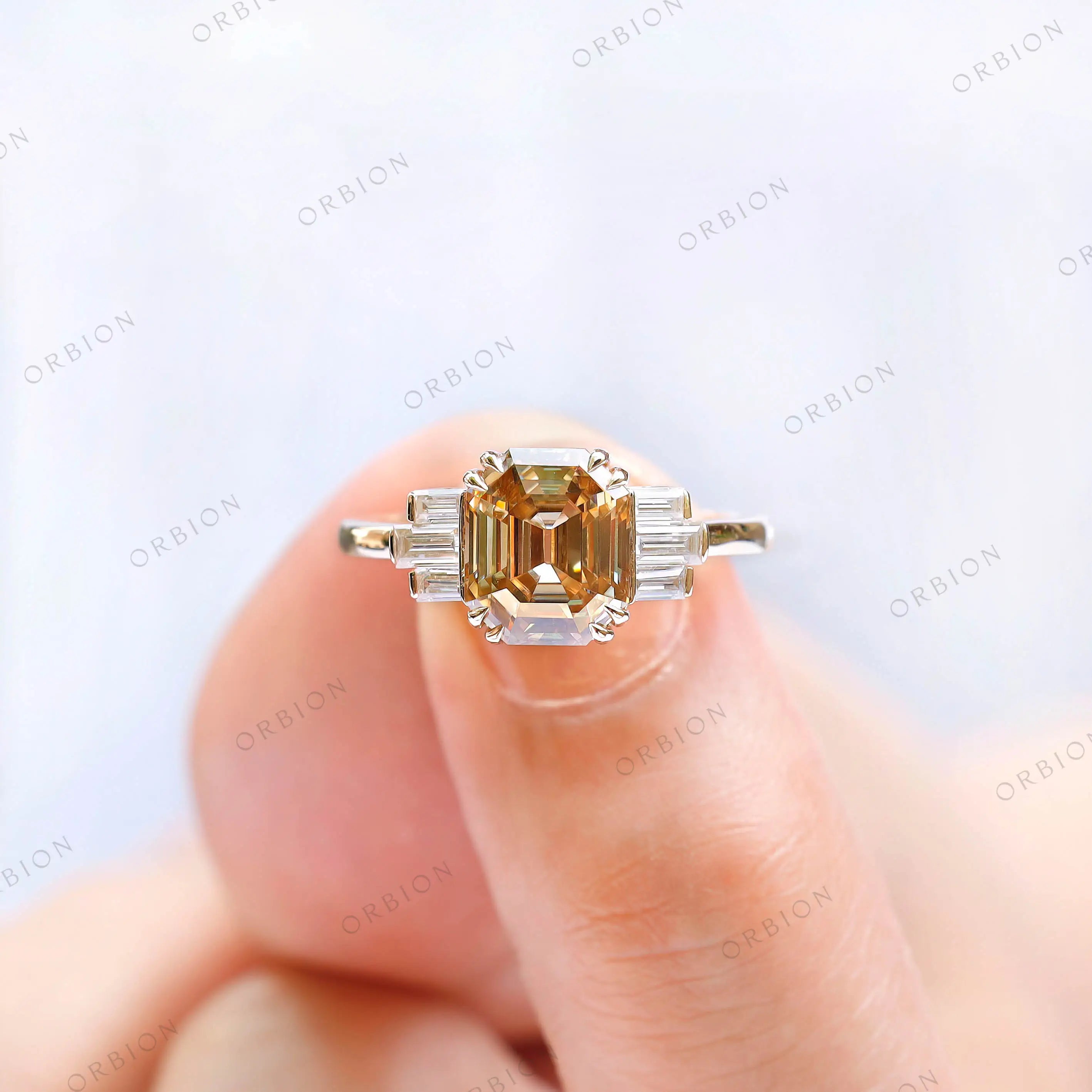 Close-up shot of champagne moissanite ring held on hand