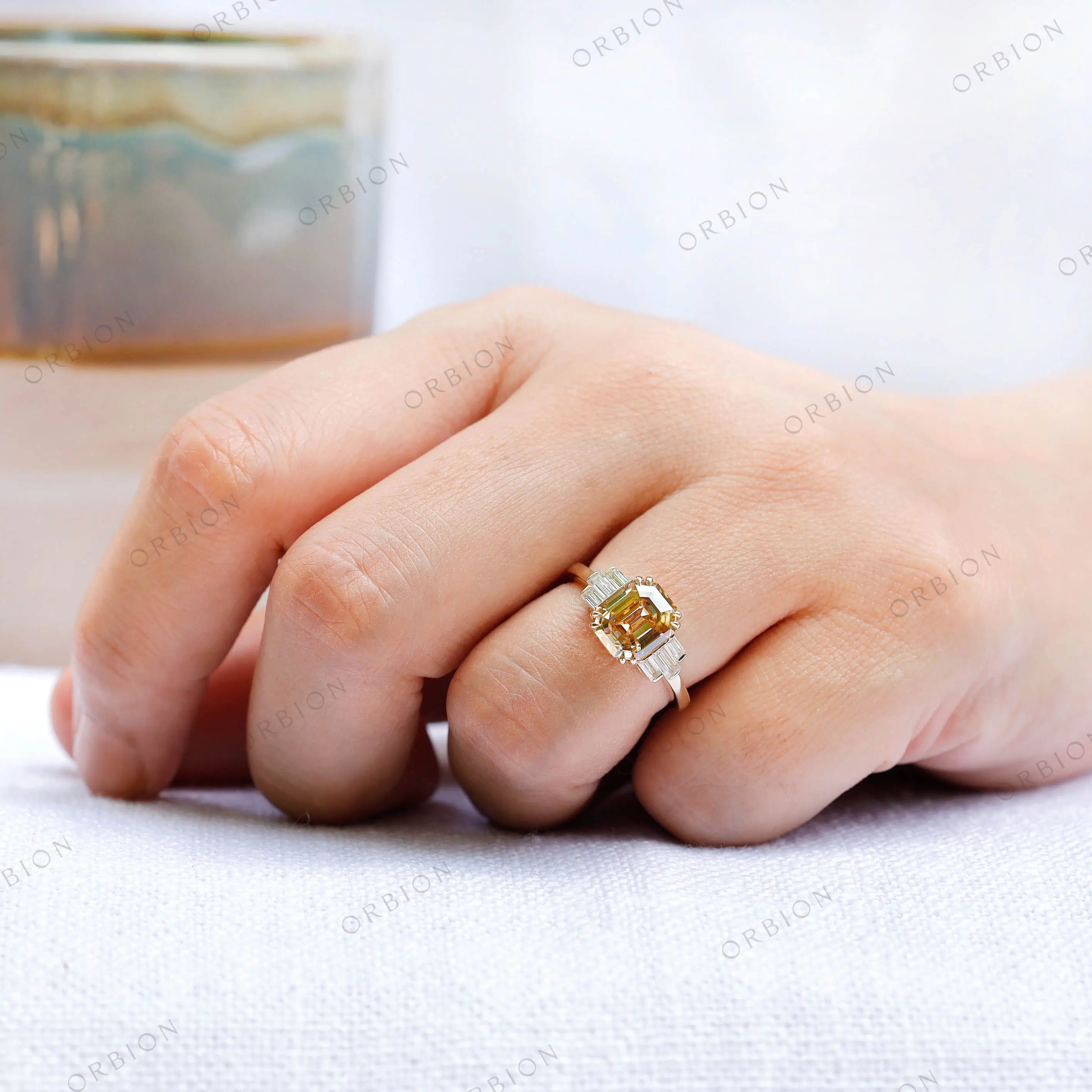 Top view of champagne moissanite ring with emerald cut center stone