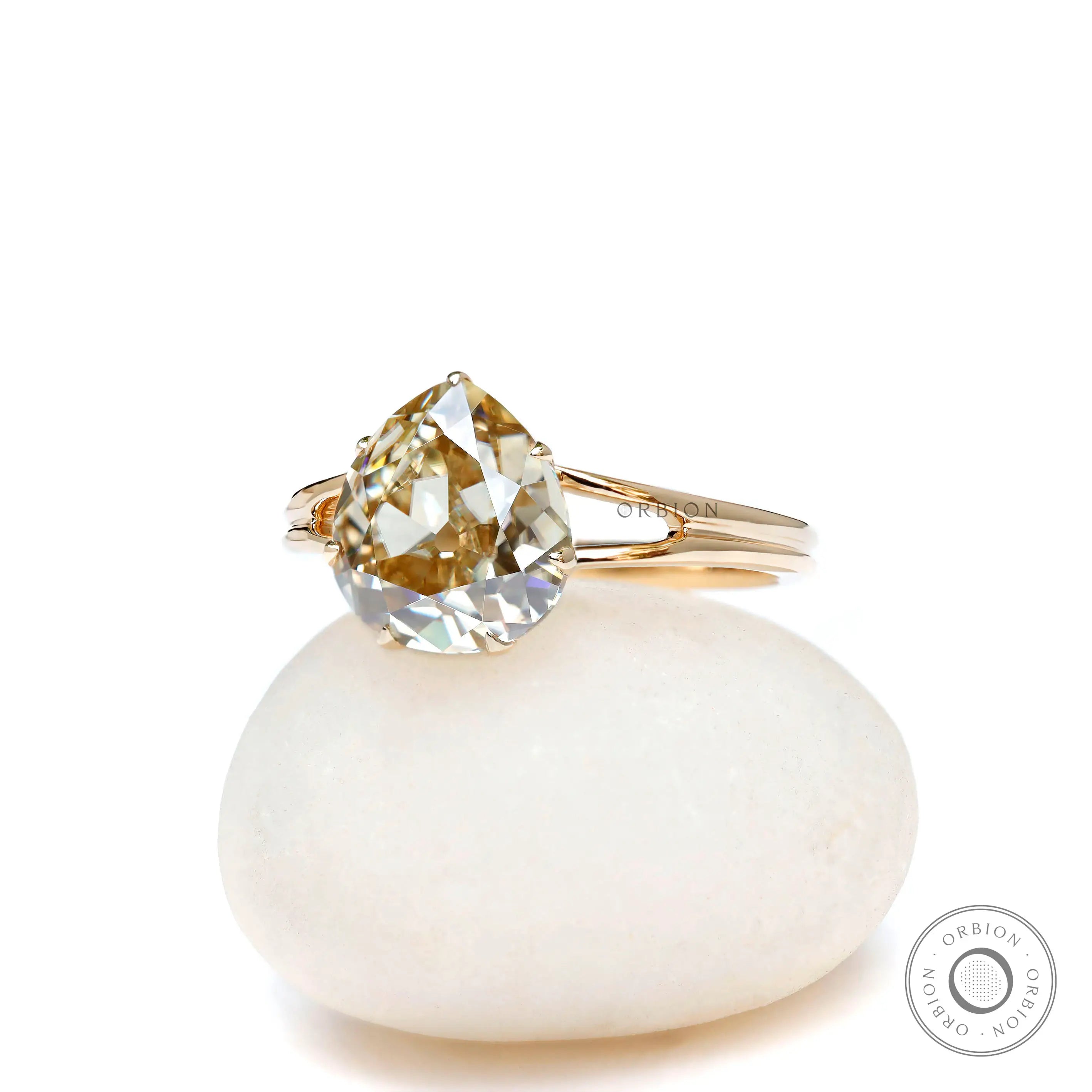 Front view of pear old mine cut champagne moissanite split shank ring in yellow gold
