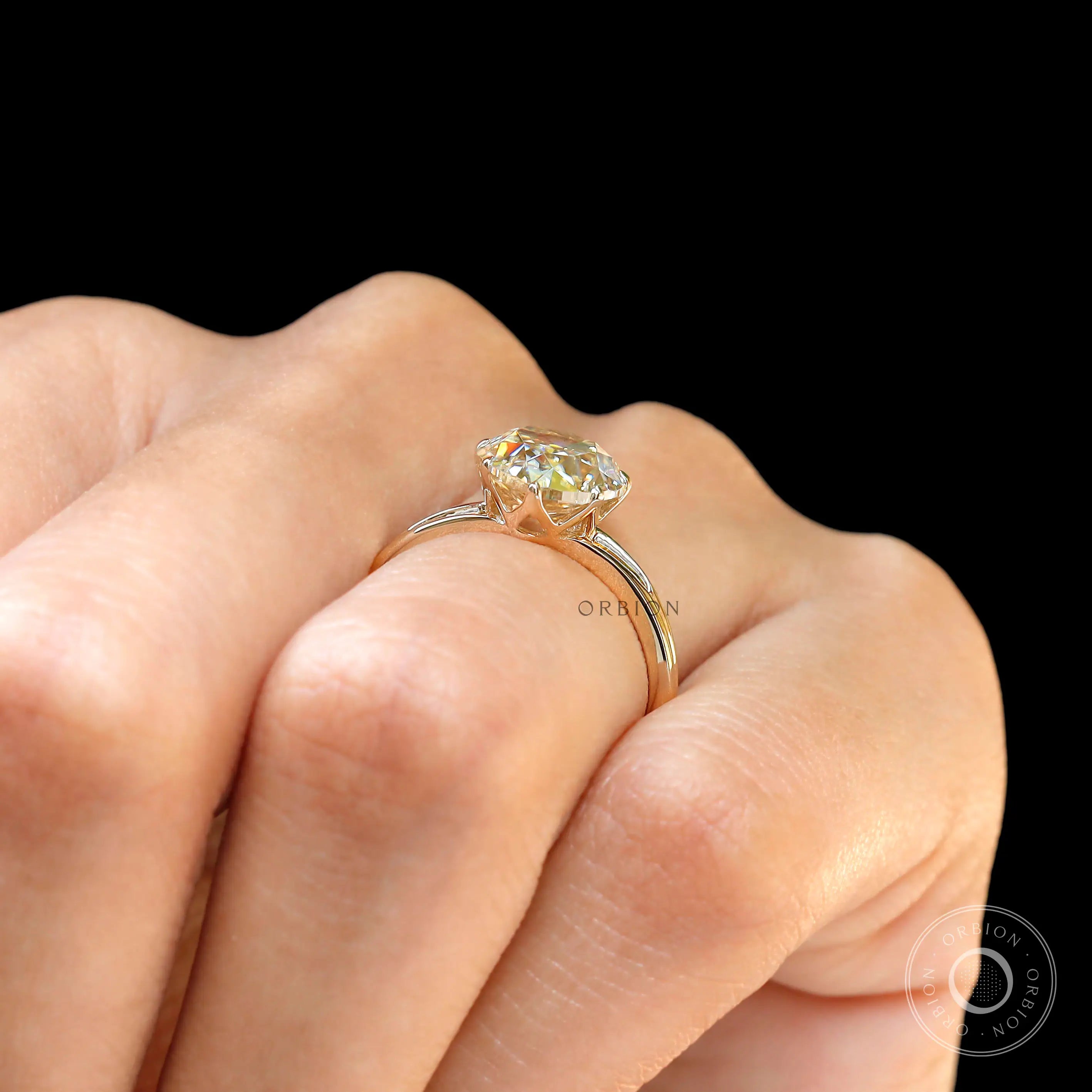 Pear old mine cut moissanite split shank ring worn on hand in yellow gold setting