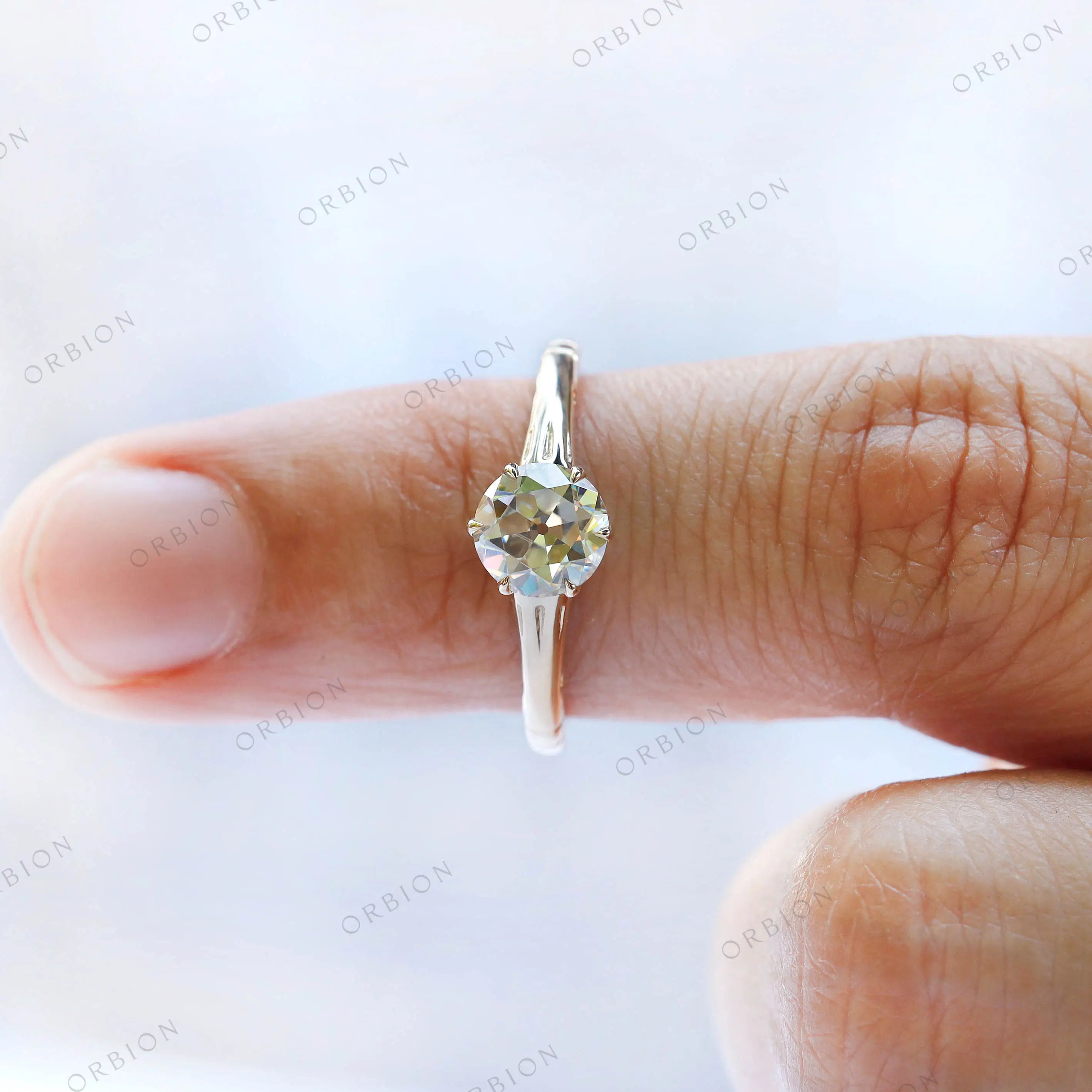 Yellow gold solitaire ring with round center stone on fingure