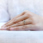 Minimalist moissanite engagement ring on finger