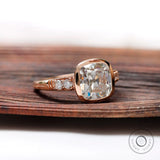 Close-up of the elongated cushion-shaped moissanite center stone, showing its Old Mine Cut and the rose gold setting.