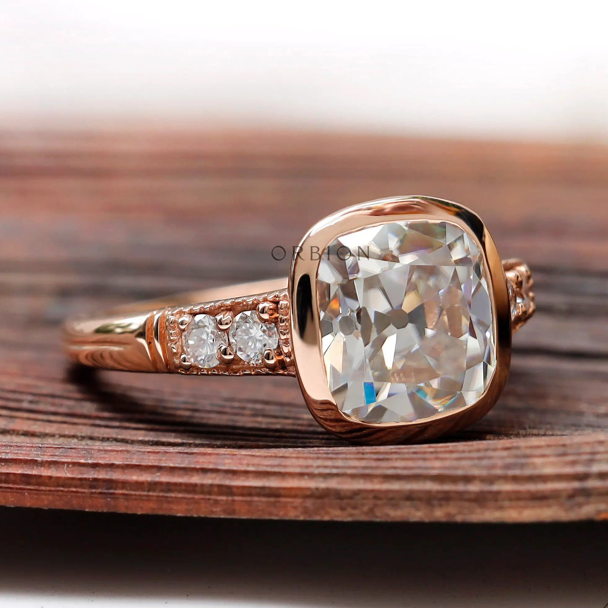 Close-up of the elongated cushion-shaped moissanite center stone, showing its Old Mine Cut and the rose gold setting.