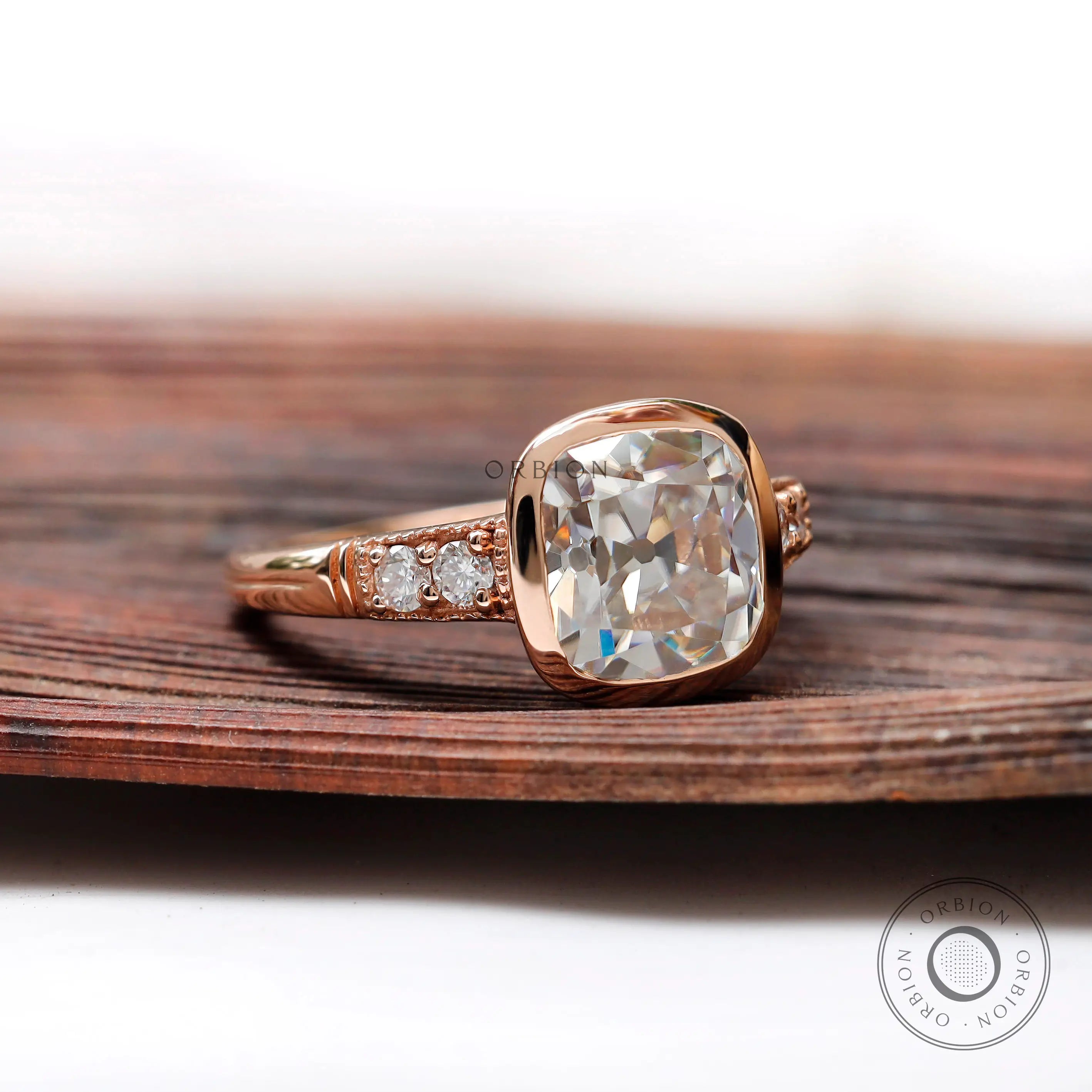 Close-up of the elongated cushion-shaped moissanite center stone, showing its Old Mine Cut and the rose gold setting.
