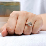 Ring shown on hand, featuring the elongated cushion moissanite center stone and round brilliant-cut side stones in 10K rose gold.