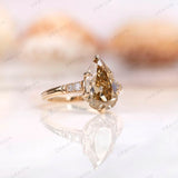 Angled view of pear-shaped champagne ring with diamond accents