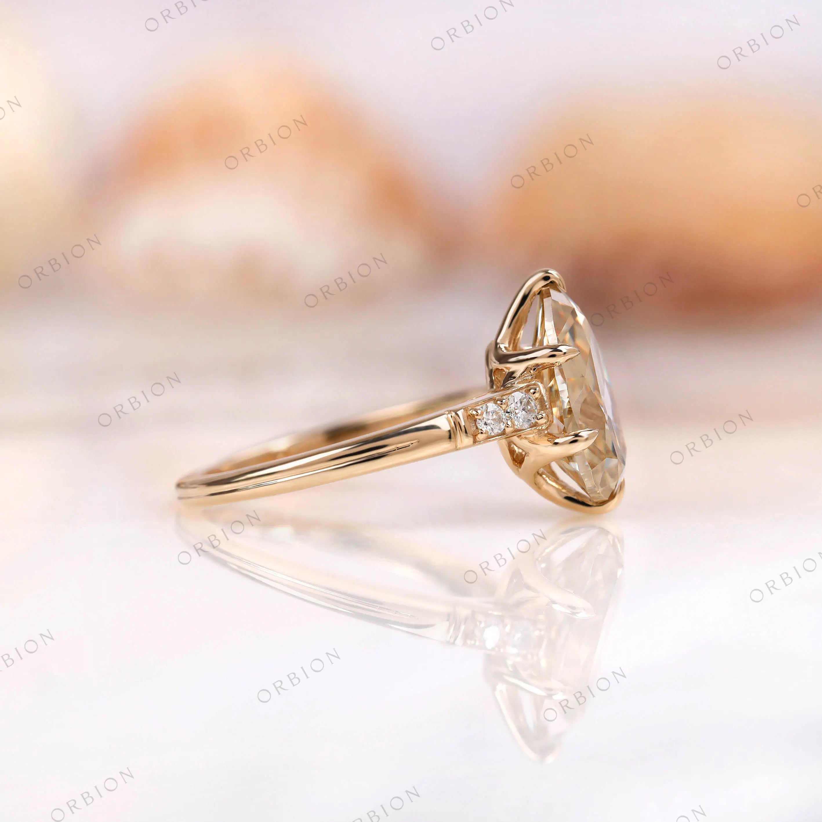 Side view of champagne moissanite pear ring with side stones