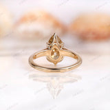 Back view of pear moissanite ring showing side profile and yellow gold band