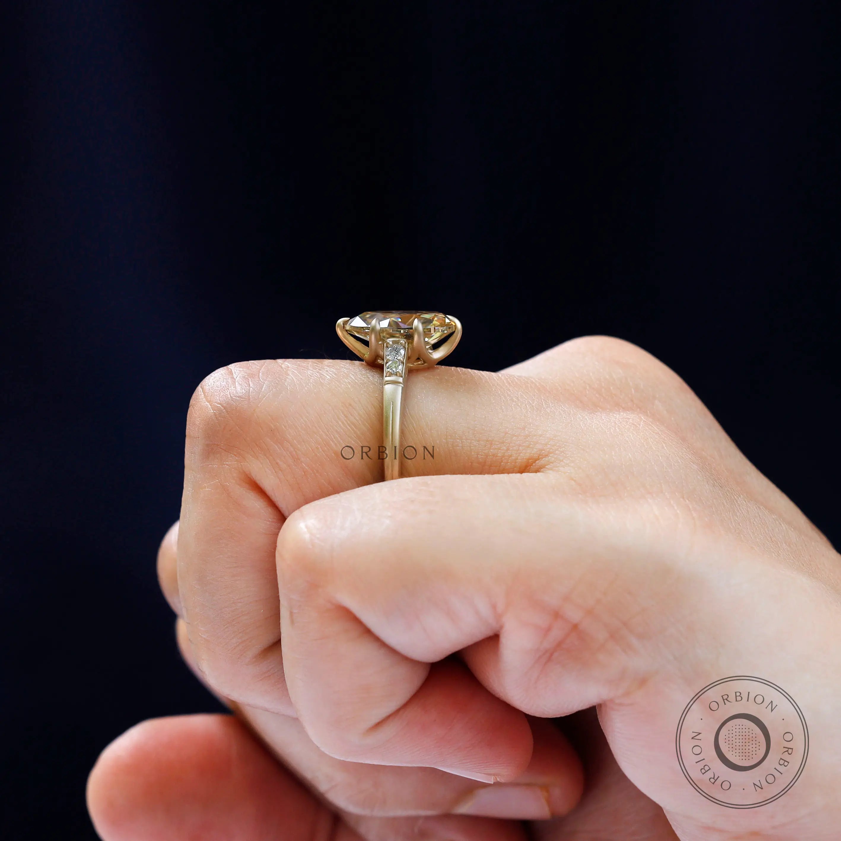 Yellow gold pear moissanite ring worn on hand