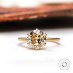 Elegant round Old European Cut light champagne moissanite solitaire engagement ring in 10K yellow gold.