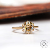 Angled side view of the round Old European Cut light champagne moissanite solitaire engagement ring in yellow gold.