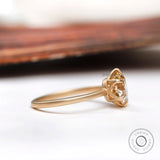 Side profile showing the prong setting and high polish yellow gold band of the round moissanite engagement ring.