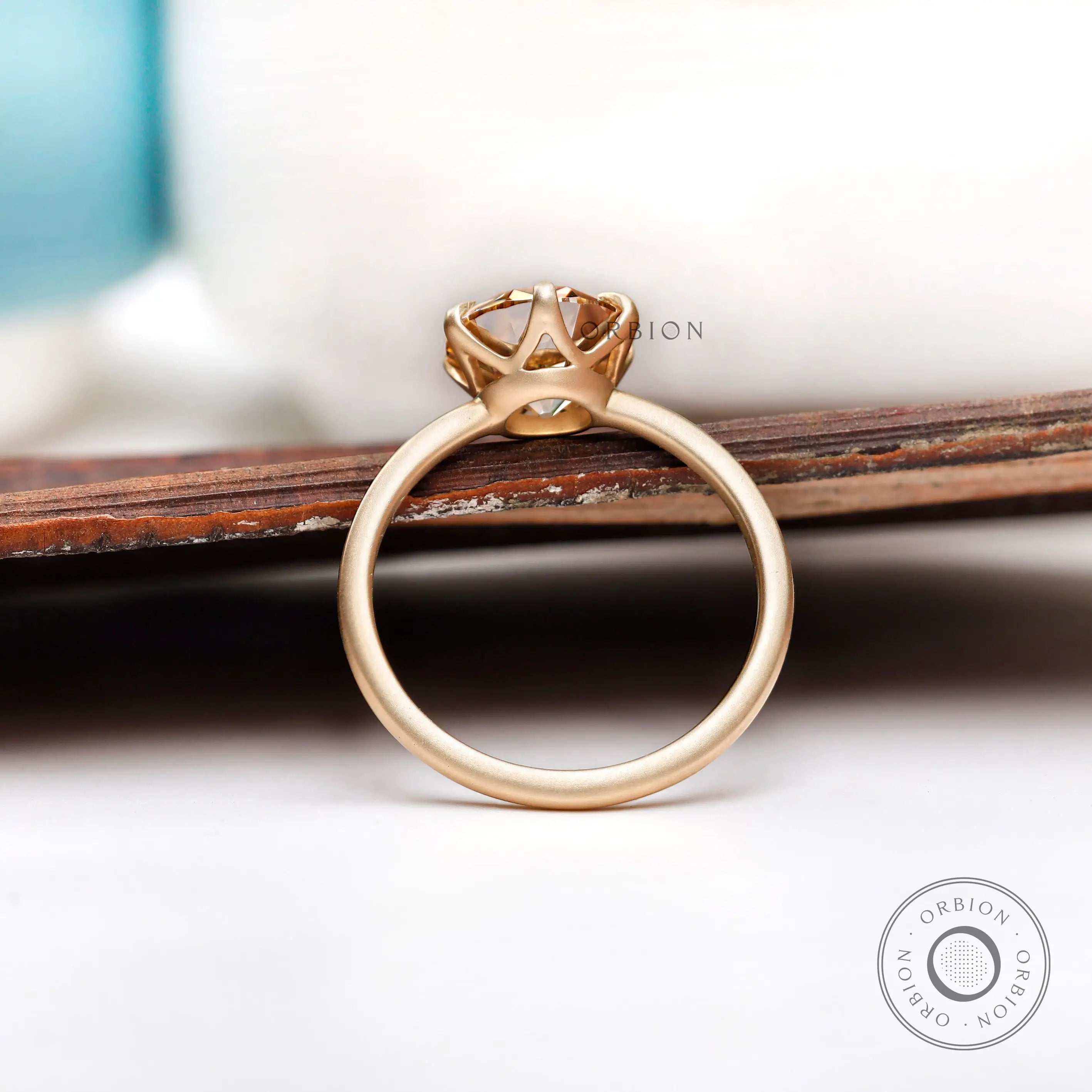 Round Old European Cut light champagne moissanite solitaire engagement ring in yellow gold with a polished band.