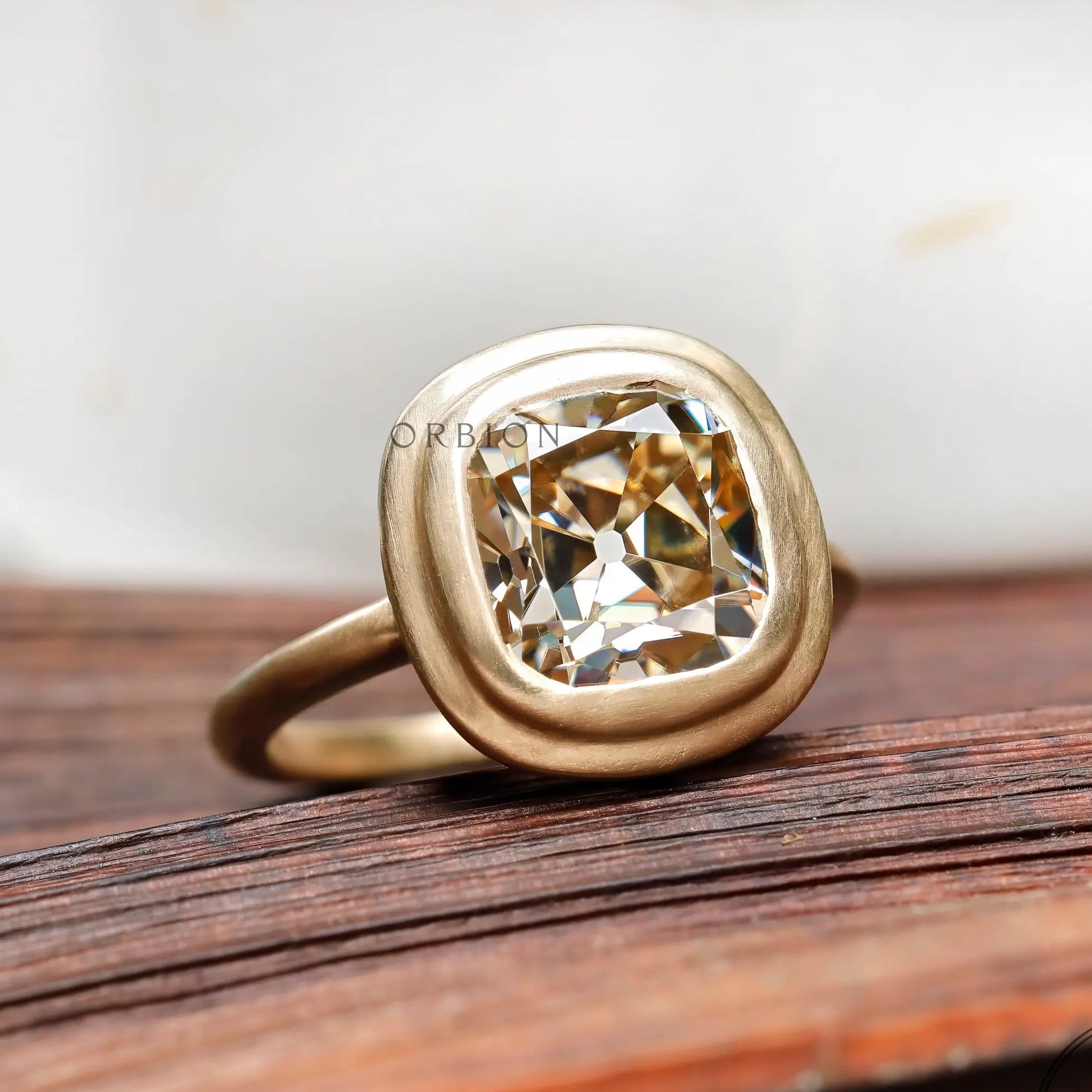 Bezel set elongated cushion light champagne moissanite solitaire ring in 10K yellow gold