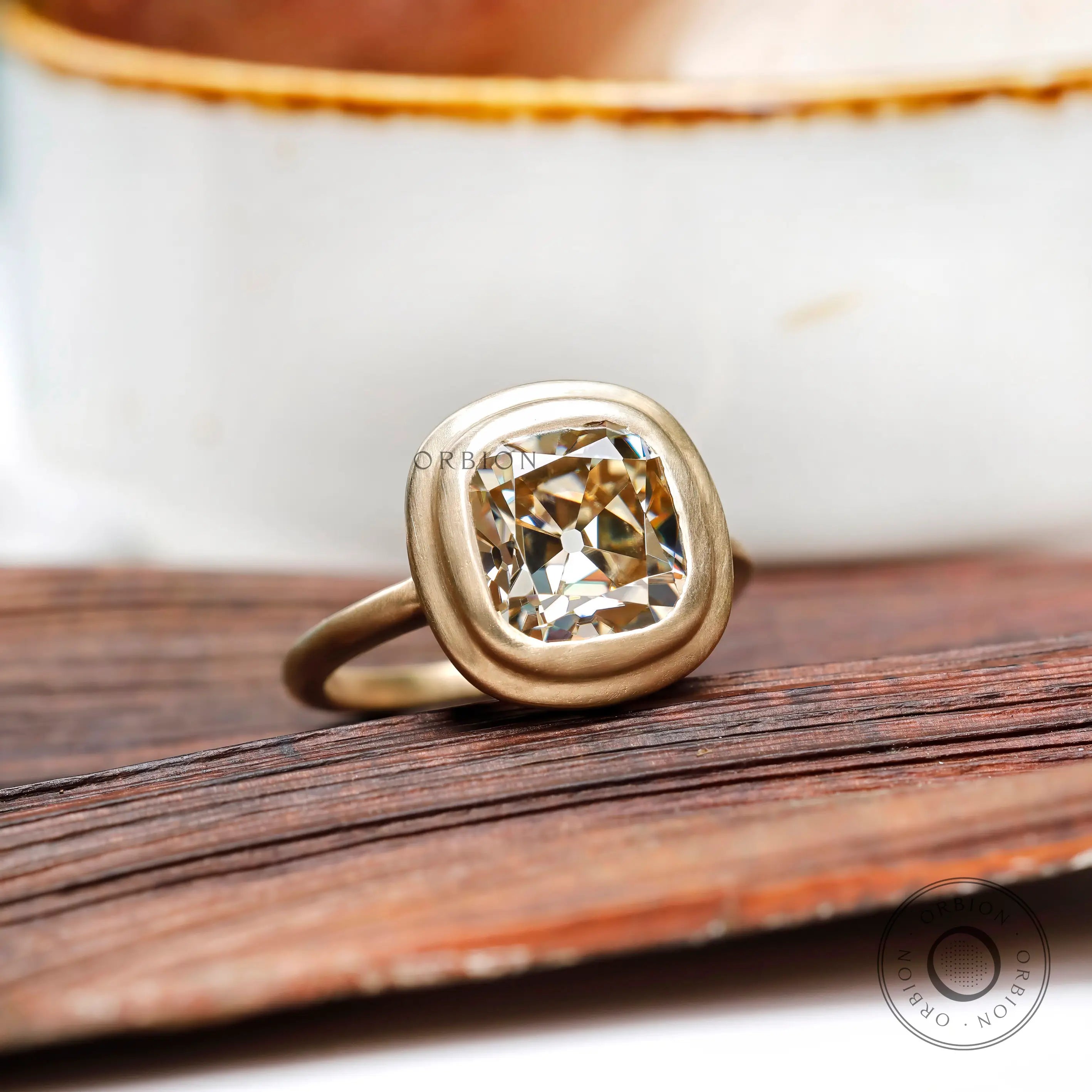 Bezel set elongated cushion light champagne moissanite solitaire ring in 10K yellow gold