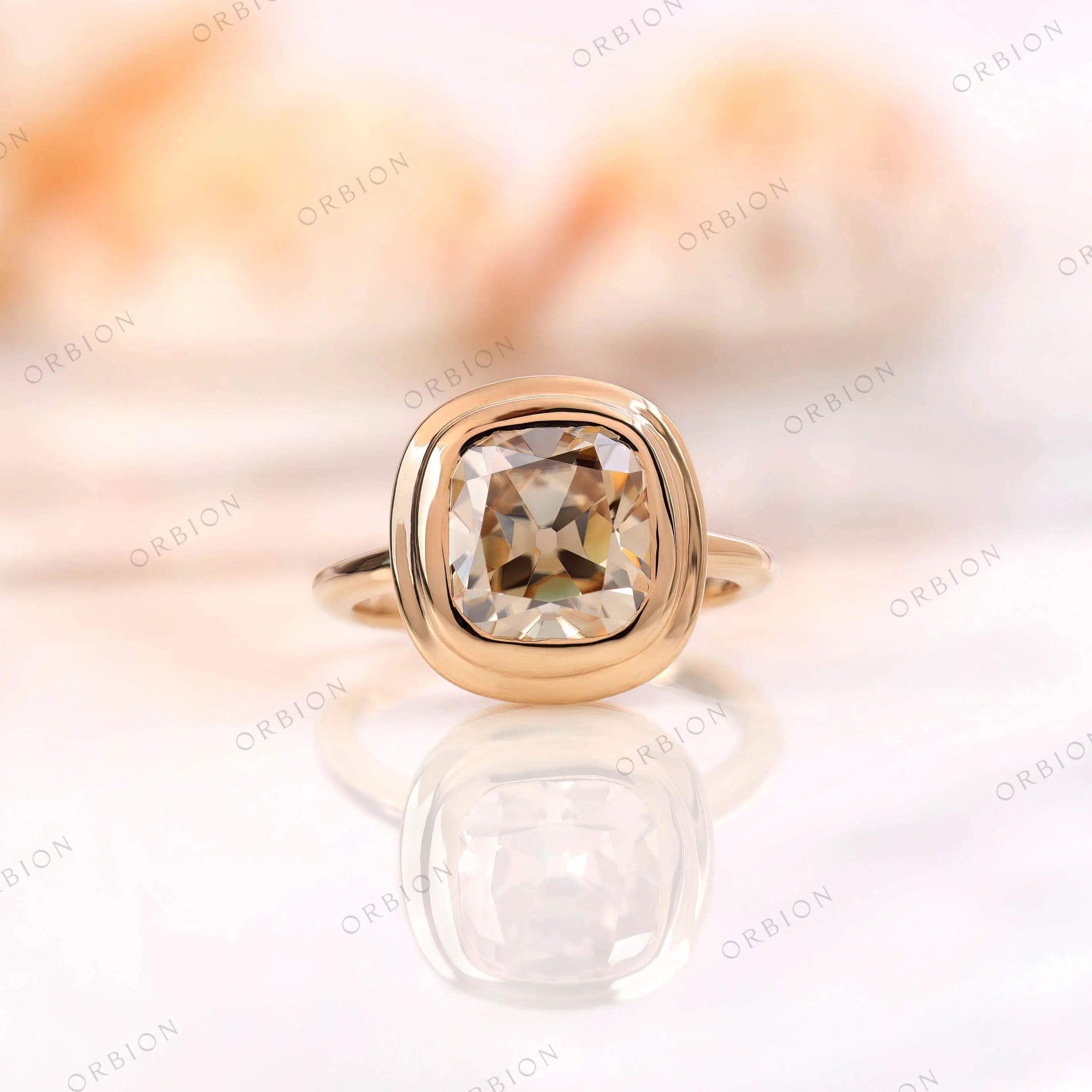 Elongated cushion moissanite in light champagne, old mine cut, set in 10K yellow gold engagement ring with a high-polish finish