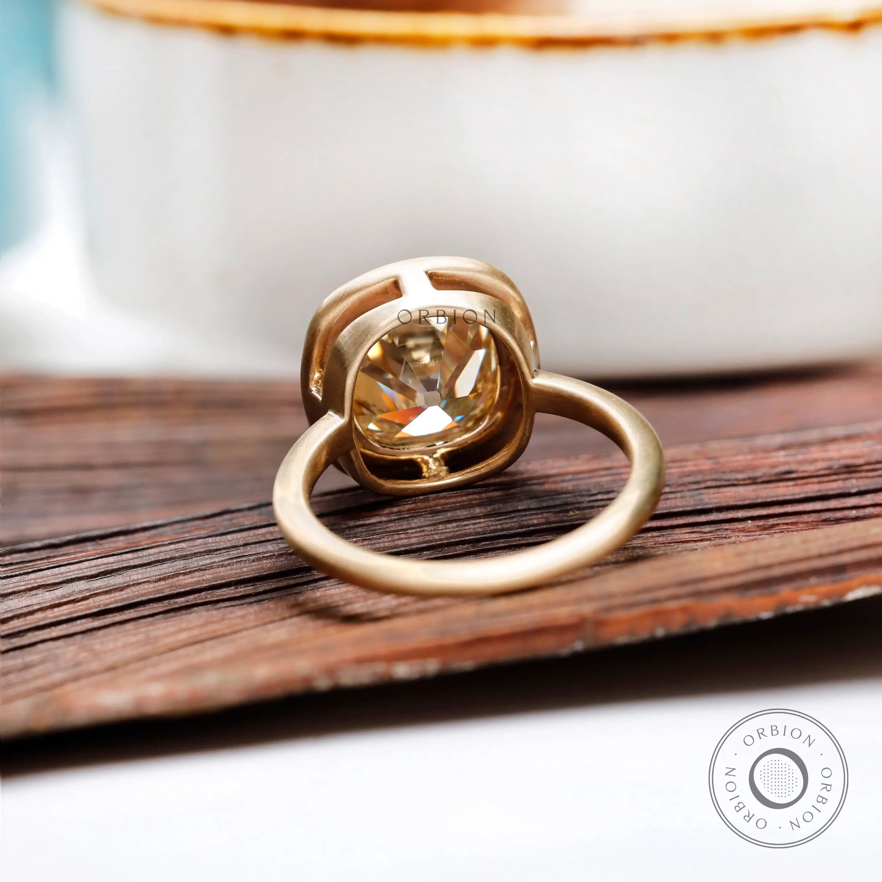 Back view of bezel set elongated cushion moissanite ring in yellow gold
