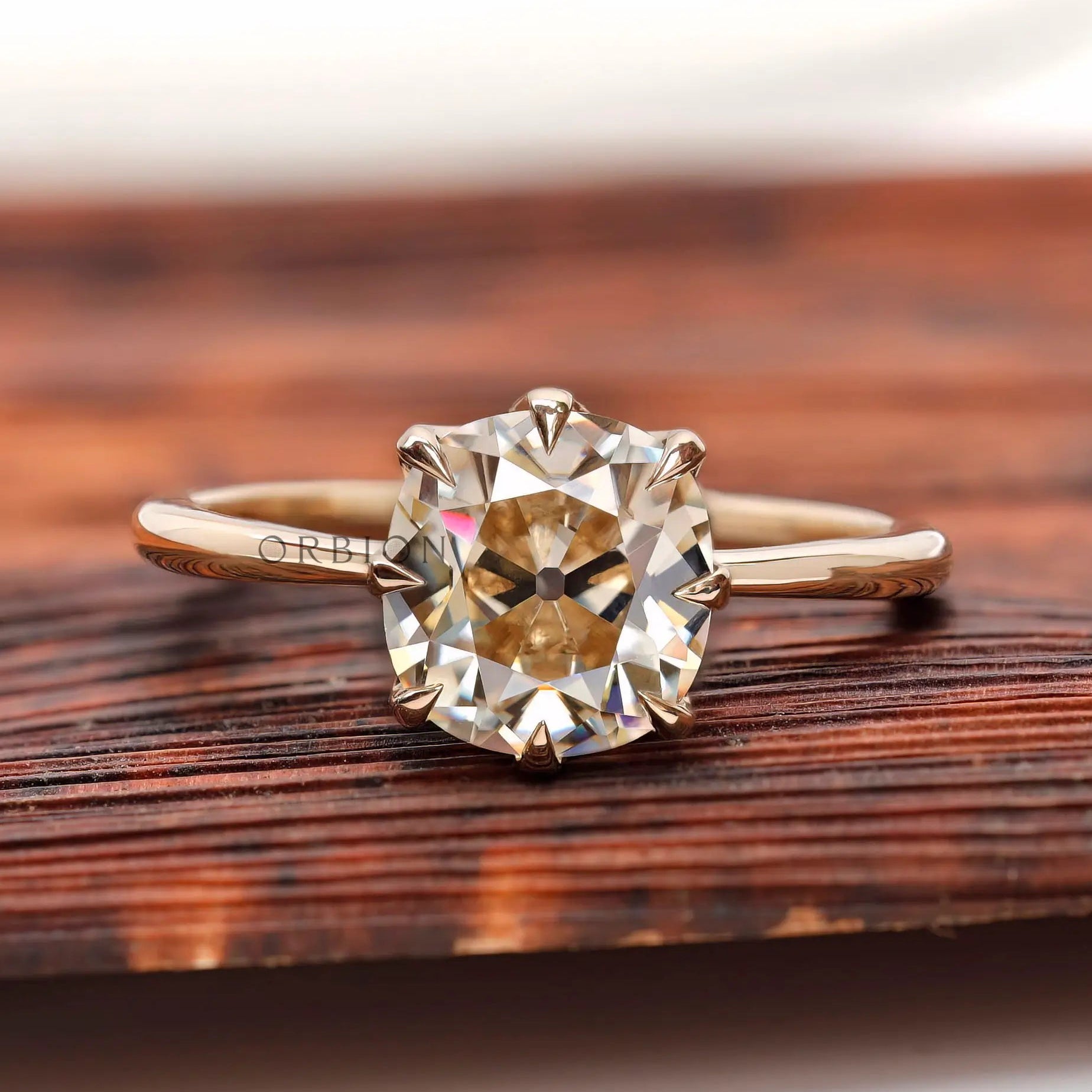 Elongated cushion old mine cut light champagne moissanite solitaire ring in yellow gold front view