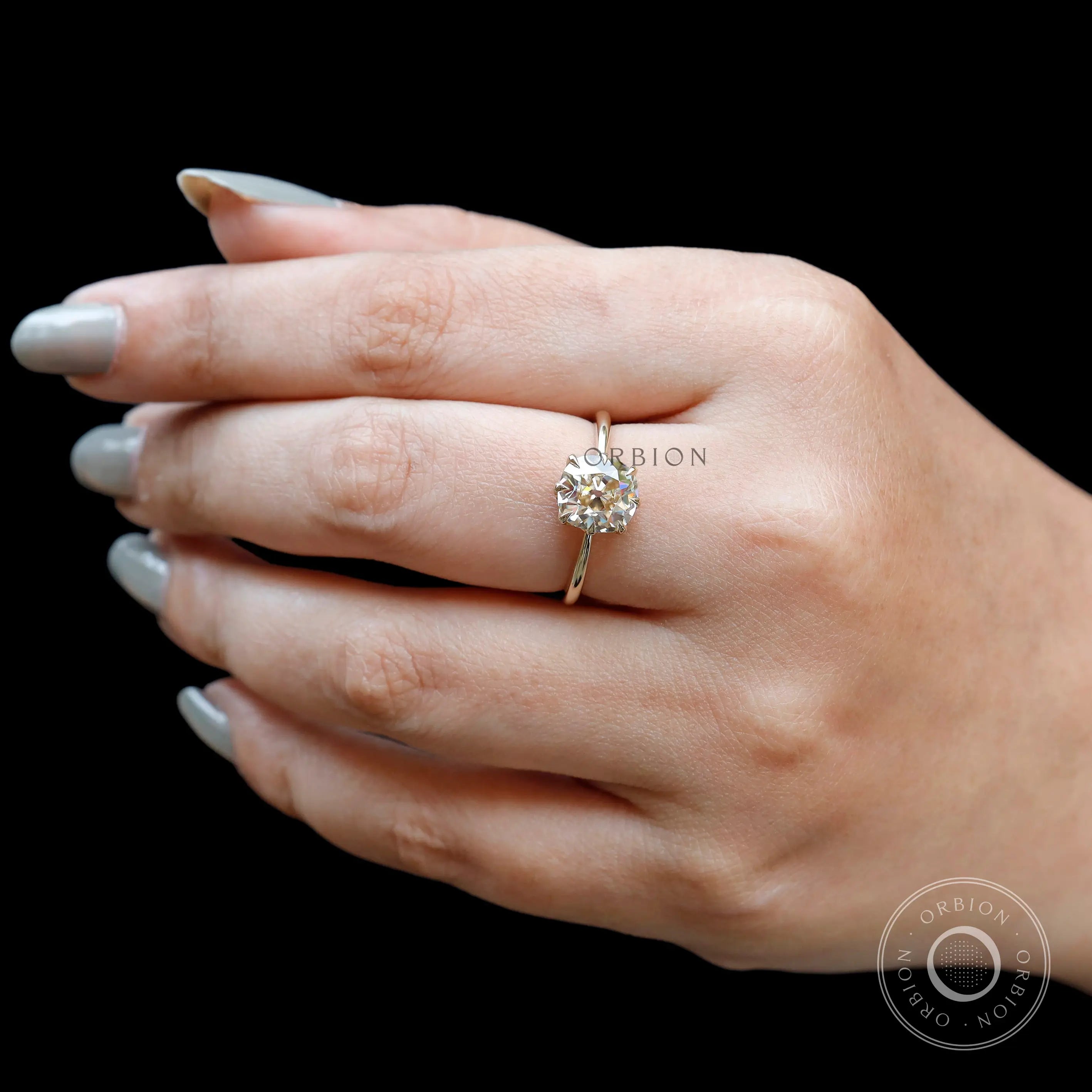 Classic solitaire ring with warm champagne tone moissanite on hand
