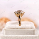 Close-up of champagne and D/E/F elongated cushion moissanites in bezel frames