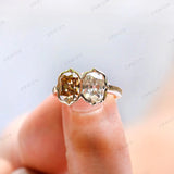Finger close-up of champagne and white moissanite bezel set two stone ring