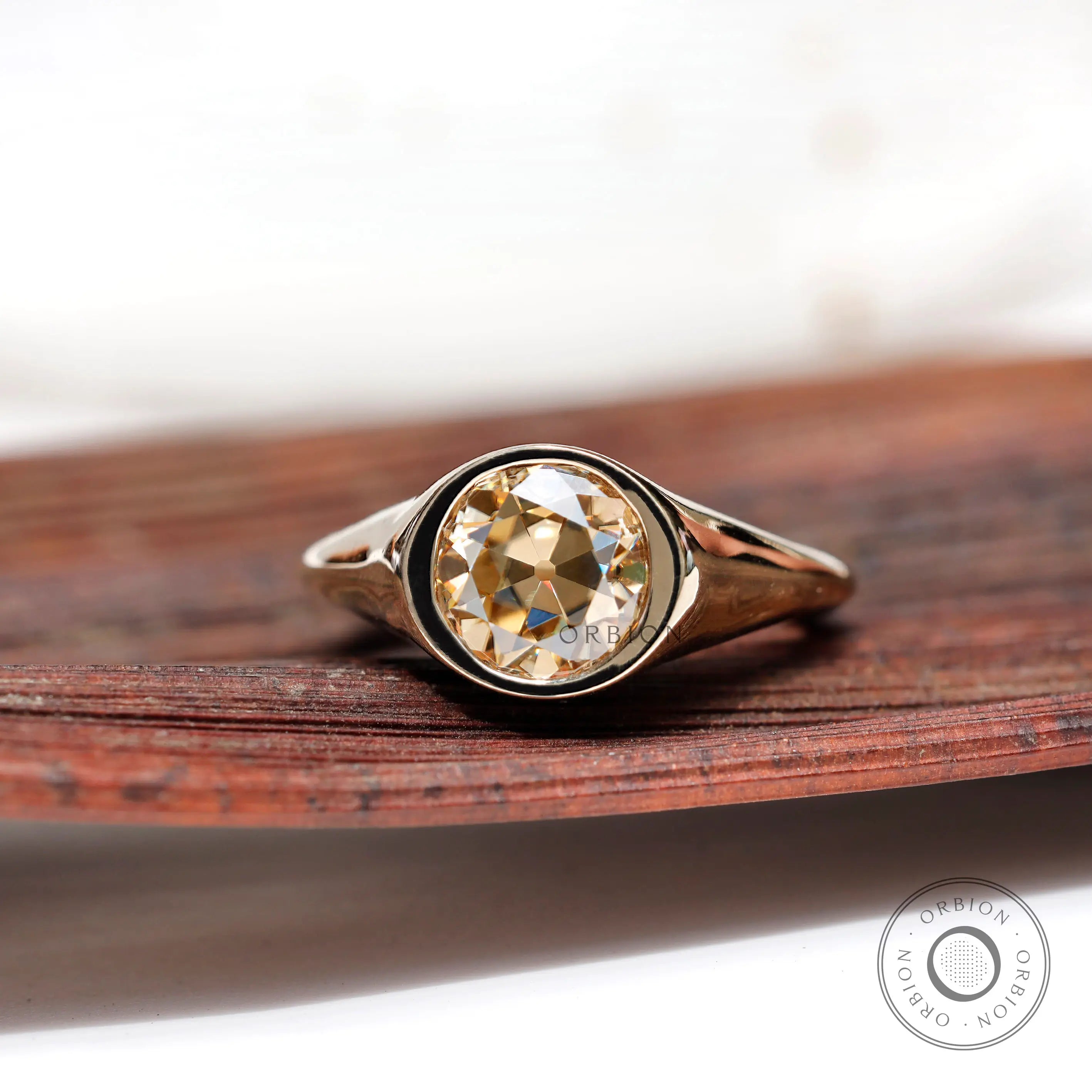 Light champagne round moissanite solitaire bezel signet ring top view